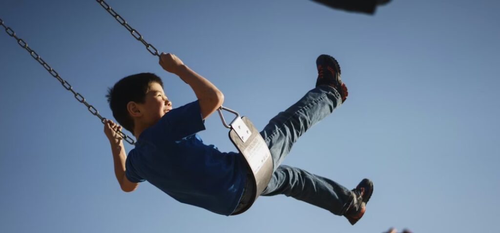 child on swingset at playground in grand rapids, mi